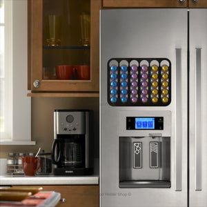 Black magnetic Nespresso Vertuo line coffee pod capsule holder shown installed on fridge freezer in kitchen.